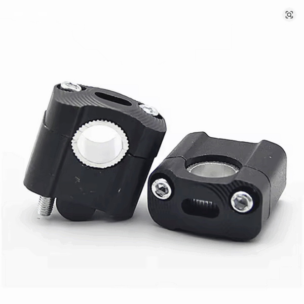 CNC machined handlebar clamp risers in black, designed as adapters to mount 22mm handlebars to 28mm fat bars for dirt bikes, shown against a neutral background.